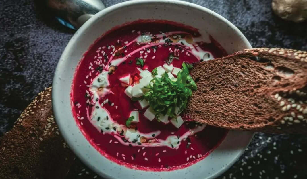 Woman dipping bread into a warm bowl of soup